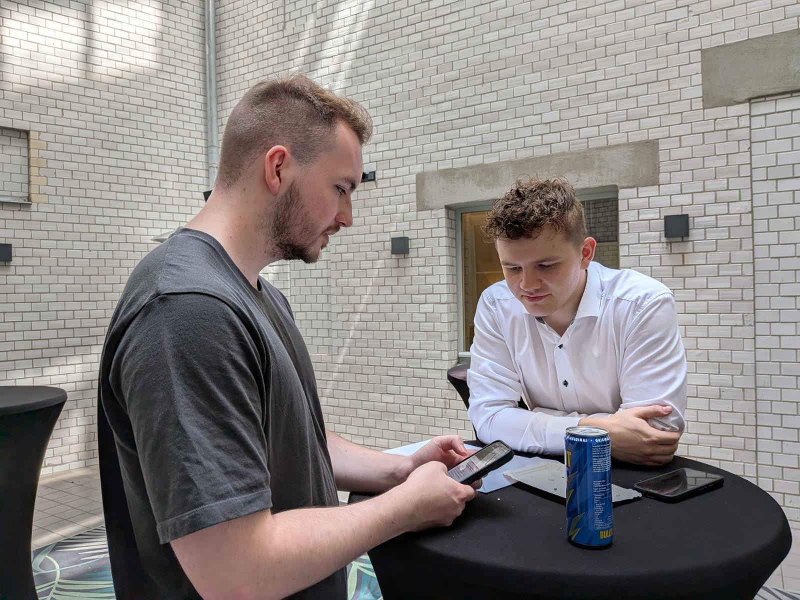 Felix Schreiber and Johannes Kanthak discussing something at a standing table