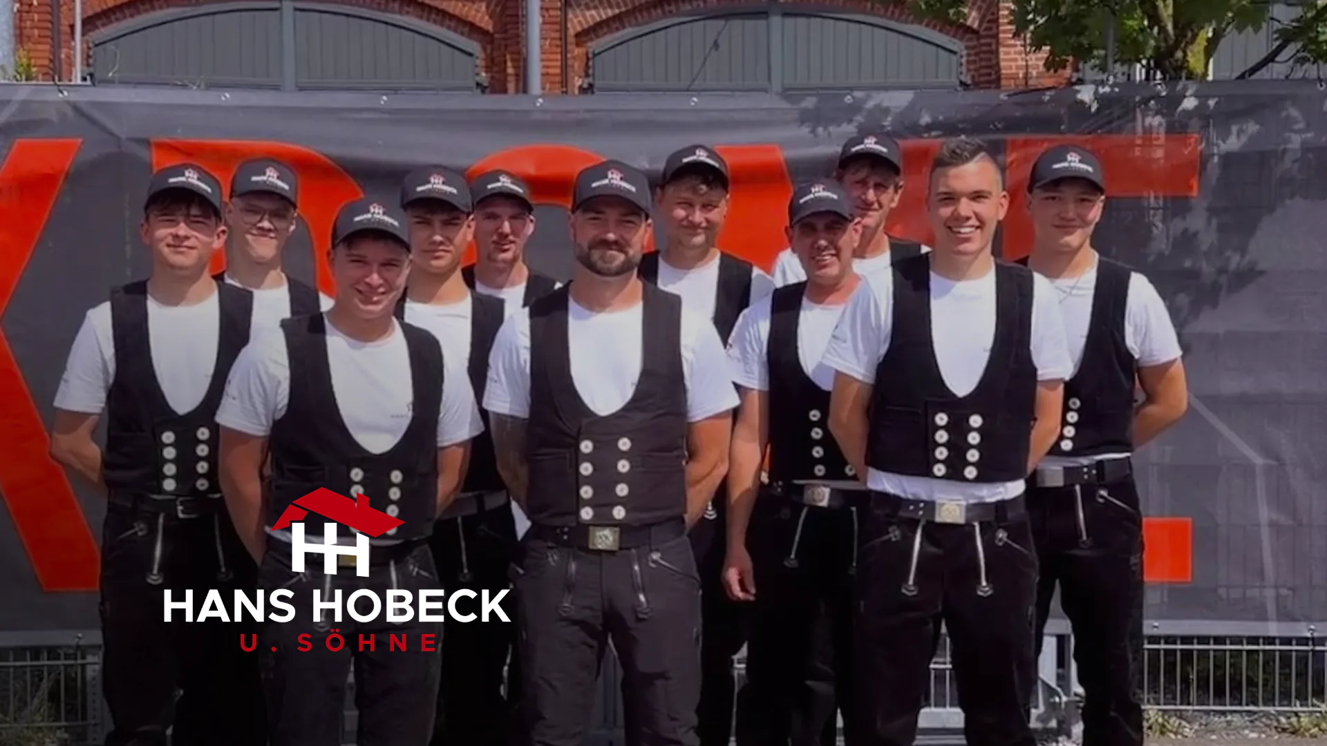 Gruppenfoto des Teams von Hans Hobeck u. Söhne in Zunftkleidung, unten links das Hobeck-Logo