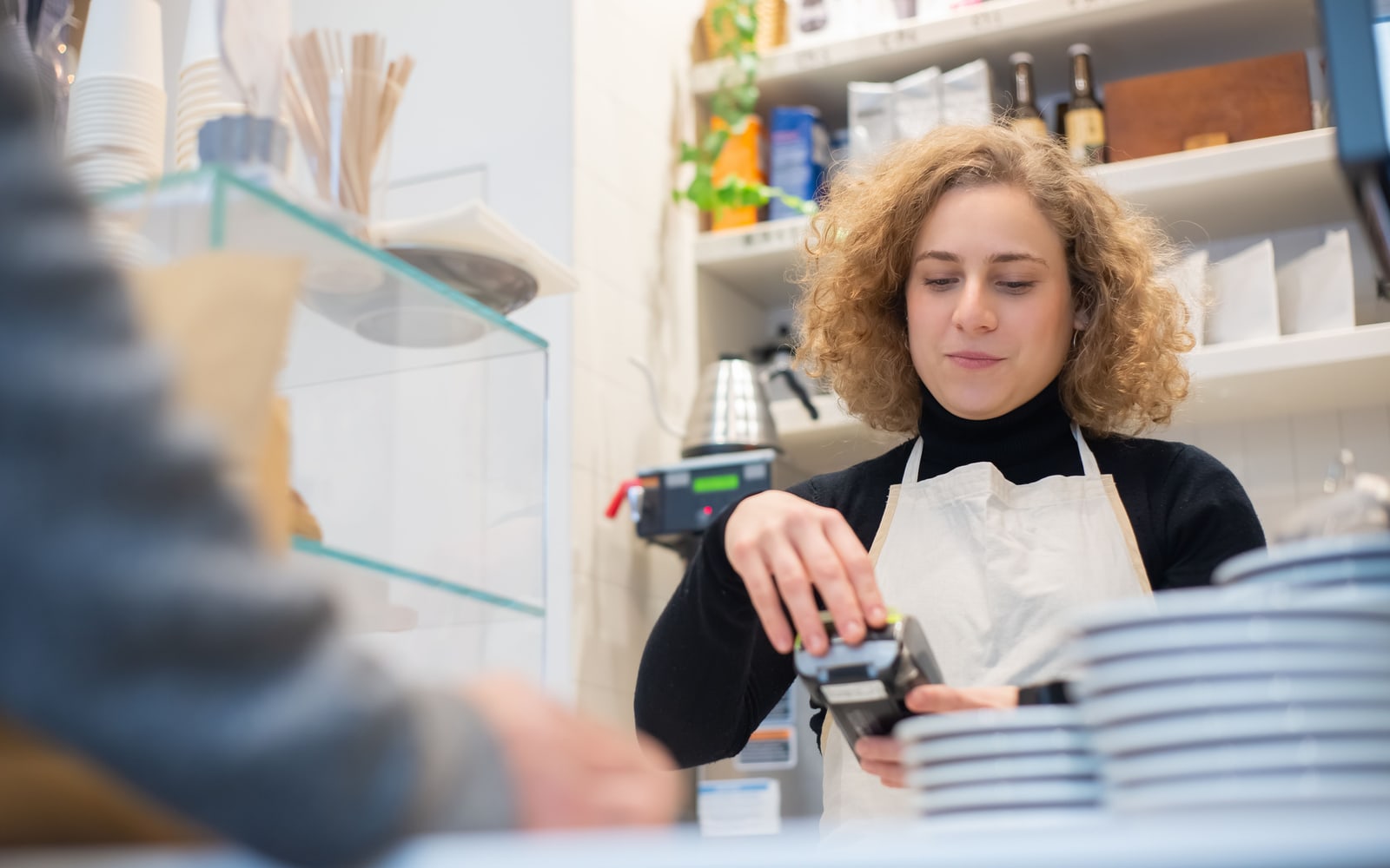 Symbolbild aus der Gastronomie: Mitarbeiterin bedient ein Kassensystem